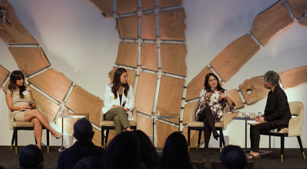 Phi Nguyen, Grace Pai, Aarti Kohli, and Wendy Tokuda sit on chairs as a panel on stage.