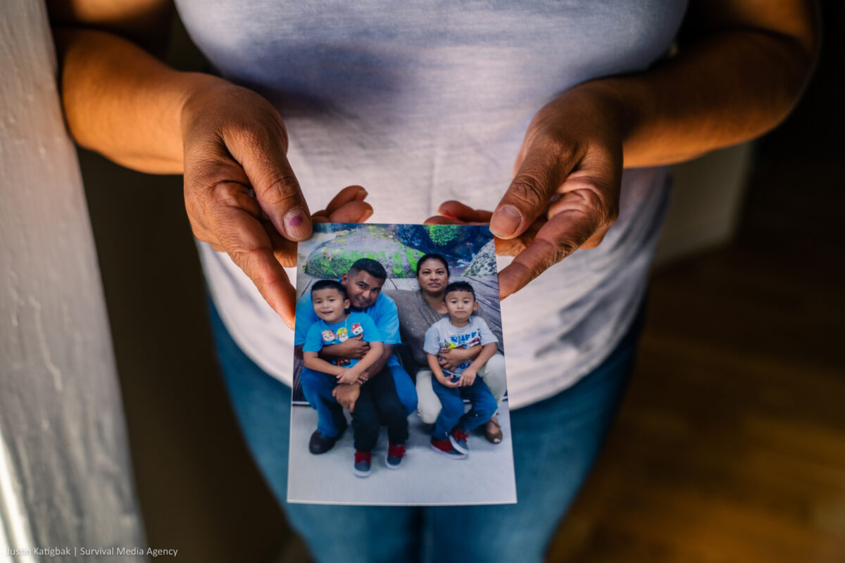Photo shows Maricela's hands holding a family photo including her son and grandkids.